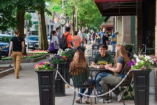 学生们坐在萨拉托加斯普林斯市中心的一家咖啡馆外面